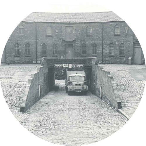Old back and white picture of the Roundhouse with an old truck parked in the Roundhouse tunnel