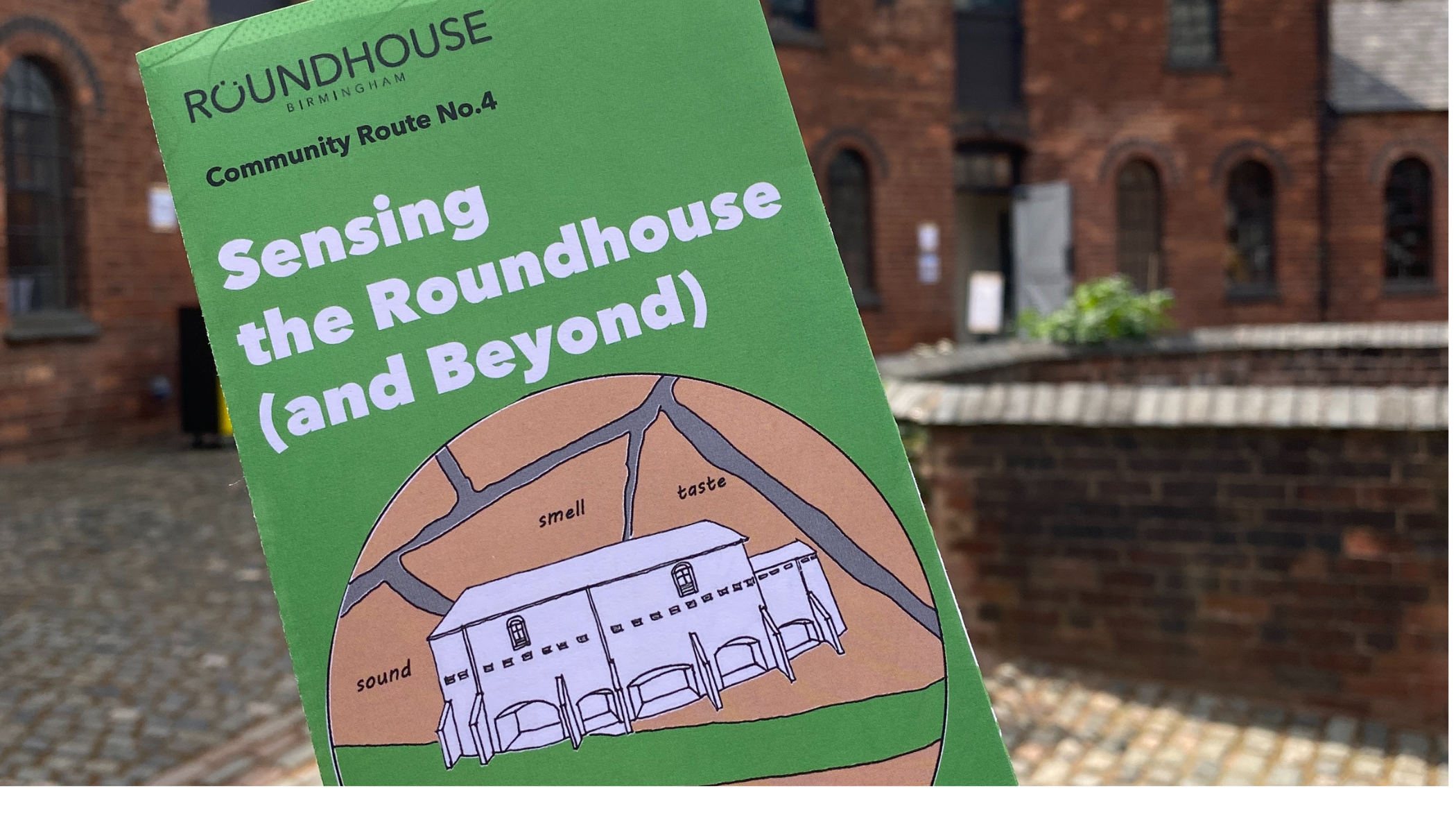 Picture of the Sensing the Roundhouse ( and Beyond) leaflet with the Roundhouse in the background