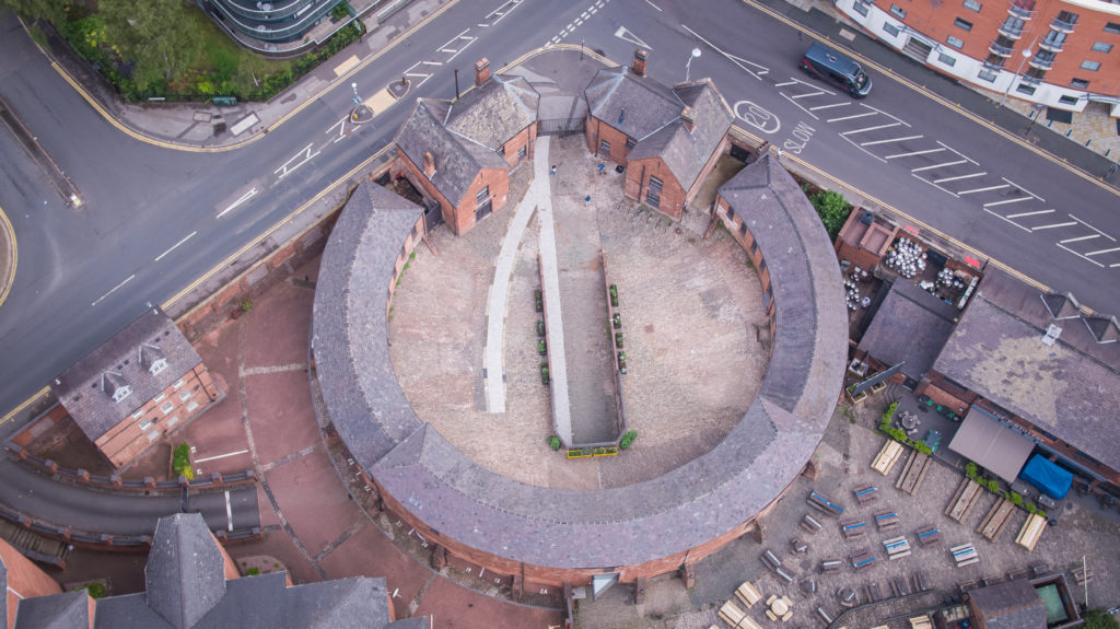 Aerial picture of Roundhouse Birmingham taken in 2021. It includes the outdoor tables at the Distillery on one side, the courtyard of the flats on the other side and the intersection of Sheepcote Street with St Vincent Street