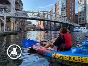 Picture of Roundhouse kayakers on the canal on a sunny day. The picture advertises the Roundhouse joining Independent Birmingham. The white Independent Birmingham logo is stamped on the picture.