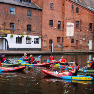 Group of 9 kayakers on the Bustling Birmingham tour outside a pub in Gas Street Basin