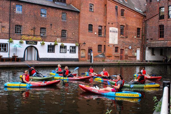 Group of 9 kayakers on the Bustling Birmingham tour outside a pub in Gas Street Basin