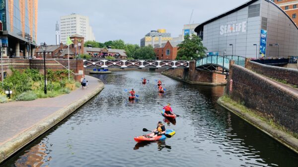 Group of six kayakers spread on the canal near Sea Life Birmingham.