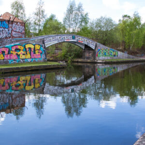Canal bridge with large amount of colourful grafitti