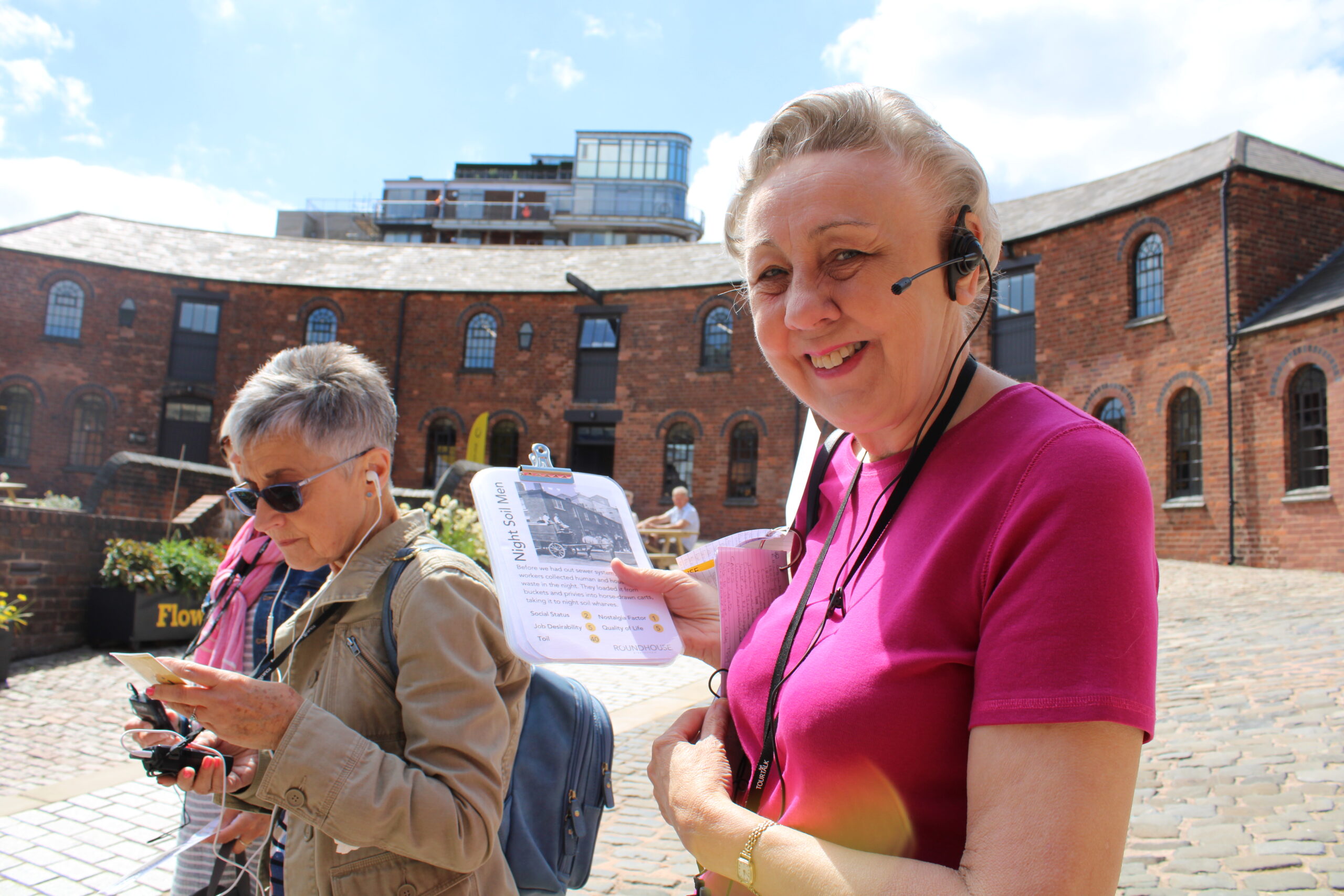 Roundhouse tour guide with visitor showing top trumps card
