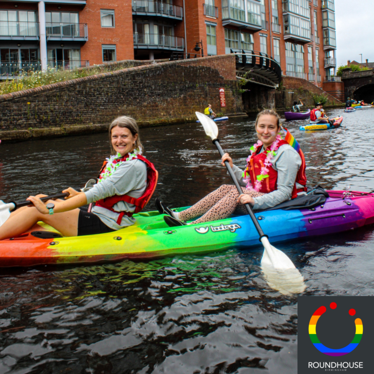 Two ladies in a rainbow coloured kayak