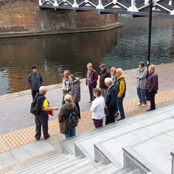 Image of tour group gathered near canal listening to a Roundhouse guide