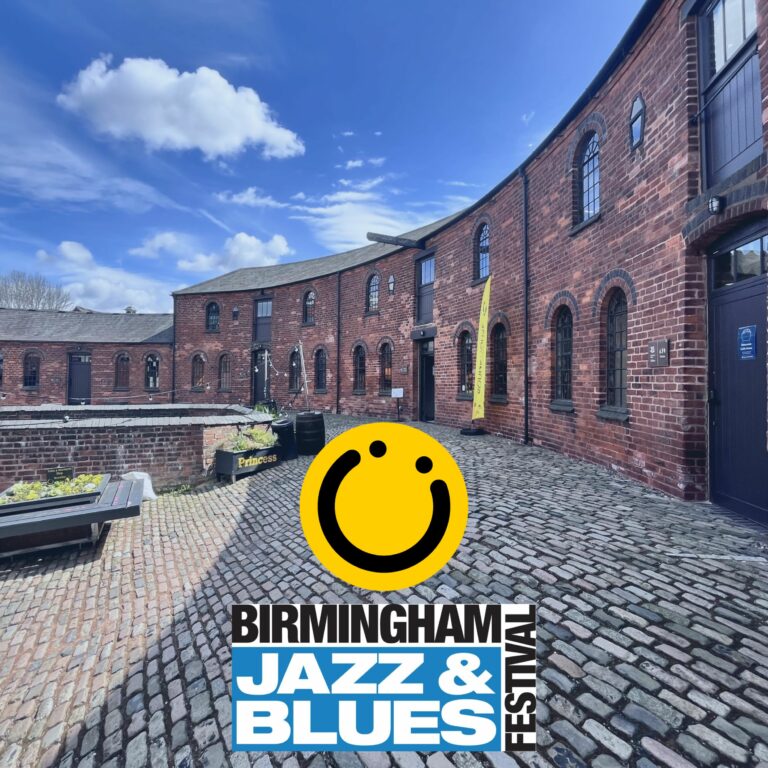 A square image showing a curved red bricked building with a cobbled flooring underneath. The sky above is blue. In the middle of the image are two logos; one is a yellow smiley face logo and the one underneath is a blue rectangle with the words 'Jazz & Blues'. Above and to the right of the box are the words 'Birmingham' and 'Festival.