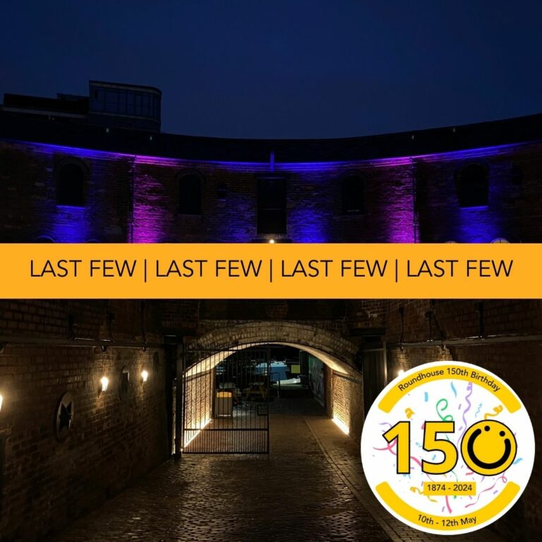A landscape image showing a large arched tunnel in the centre of the image illuminated with yellow warm light. The flooring is cobbled. Behind and above is a curved red brick walled building. There are six uplighters showing shooting colours of blue and purple. There are multiple arched windows with warm light coming from the inside. In the bottom right of the image is a graphic logo with the number 150, the 0 of the logo is a yellow smiley face logo. The 1, 5 and circular logo are outlined in black. Across the middle of the image is an orange banner with the words 'Last Few' typed on, repeated four times.
