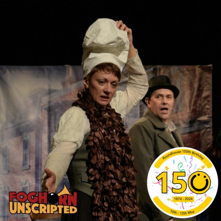 A square image showing two people. One is holding a bag on their head and the person behind is wearing a bowler hat. They both have shocked expressions on their faces. In the bottom right of the image is a graphic logo with the number 150, the 0 of the logo is a yellow smiley face logo. In the bottom left corner of the image is a logo saying 'Foghorn Unscripted'. The word foghorn is red and the word unscripted is yellow.